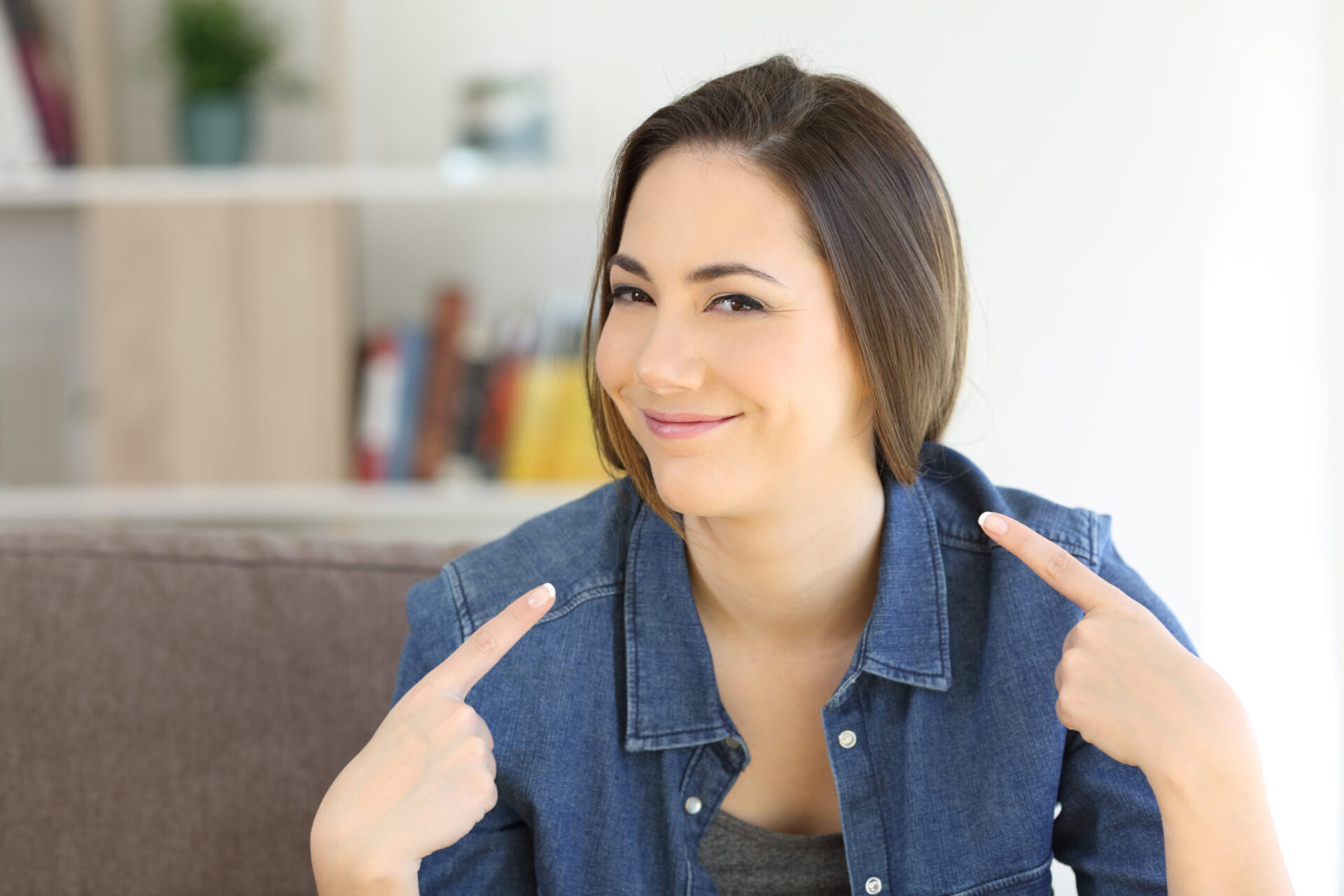 Woman smiling point both index fingers to herself